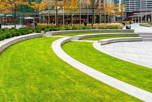 Auditorium style sitting area with grass in outdoor courtyard